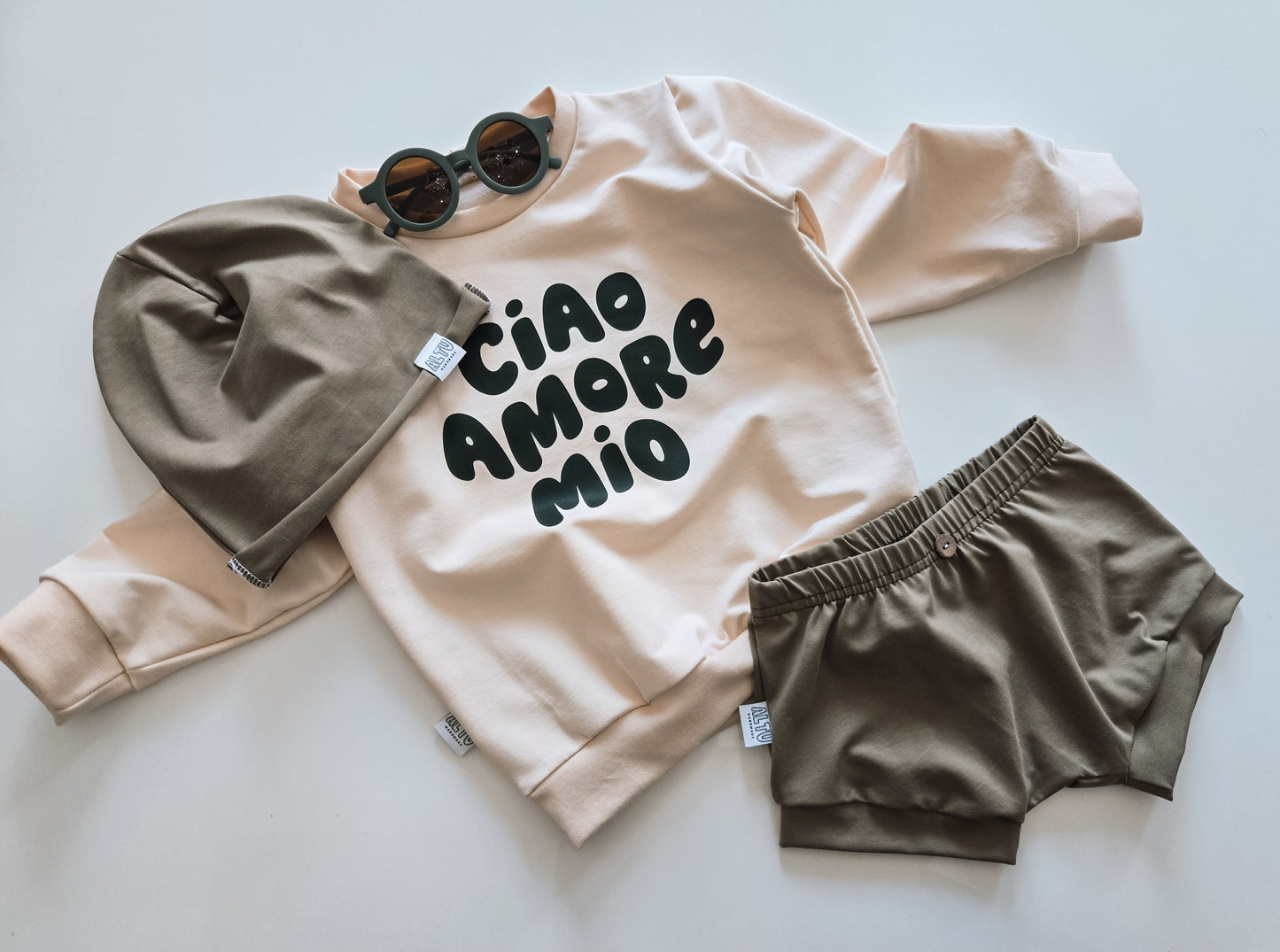 Handgemachter Baby- und Kinder-Sweater in Cremefarbe mit "Ciao Amore Mio"-Patch, aus weichen, organischen Stoffen. Nachhaltig, gemütlich und unisex.

