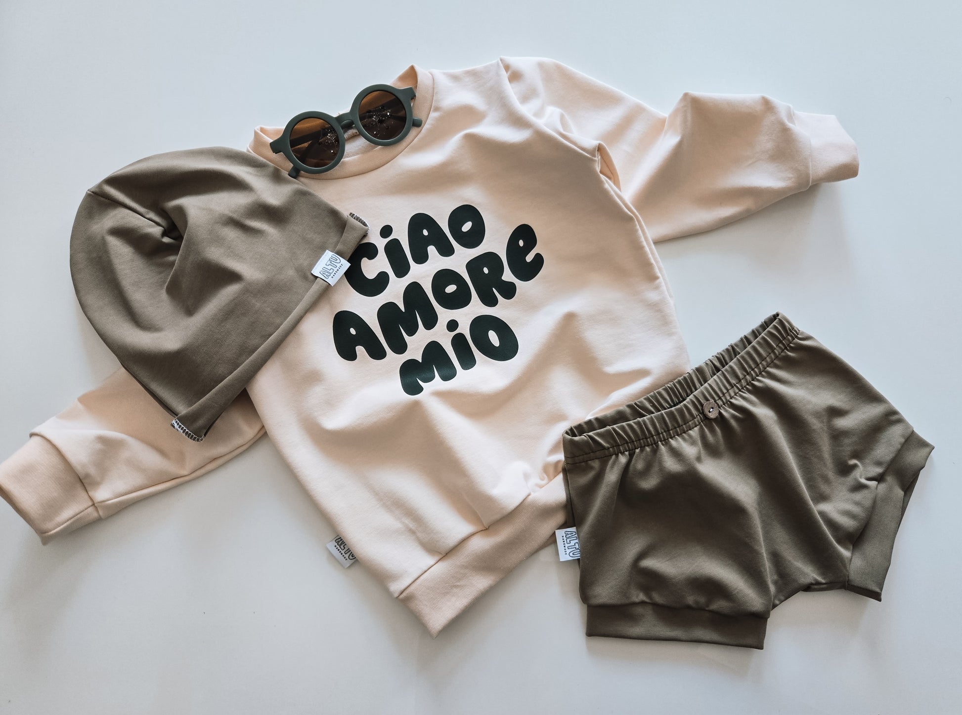 Handgemachter Baby- und Kinder-Sweater in Cremefarbe mit "Ciao Amore Mio"-Patch, aus weichen, organischen Stoffen. Nachhaltig, gemütlich und unisex.

